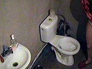 Good night ritual of sexy blonde in red nighty and slippers caught on spy camera situated in the toilet. The babe sat on the potty and smoked a cigarette having no idea she was obtrusively filmed!